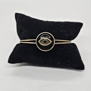 gold tone cuff bracelet with black enamel eye